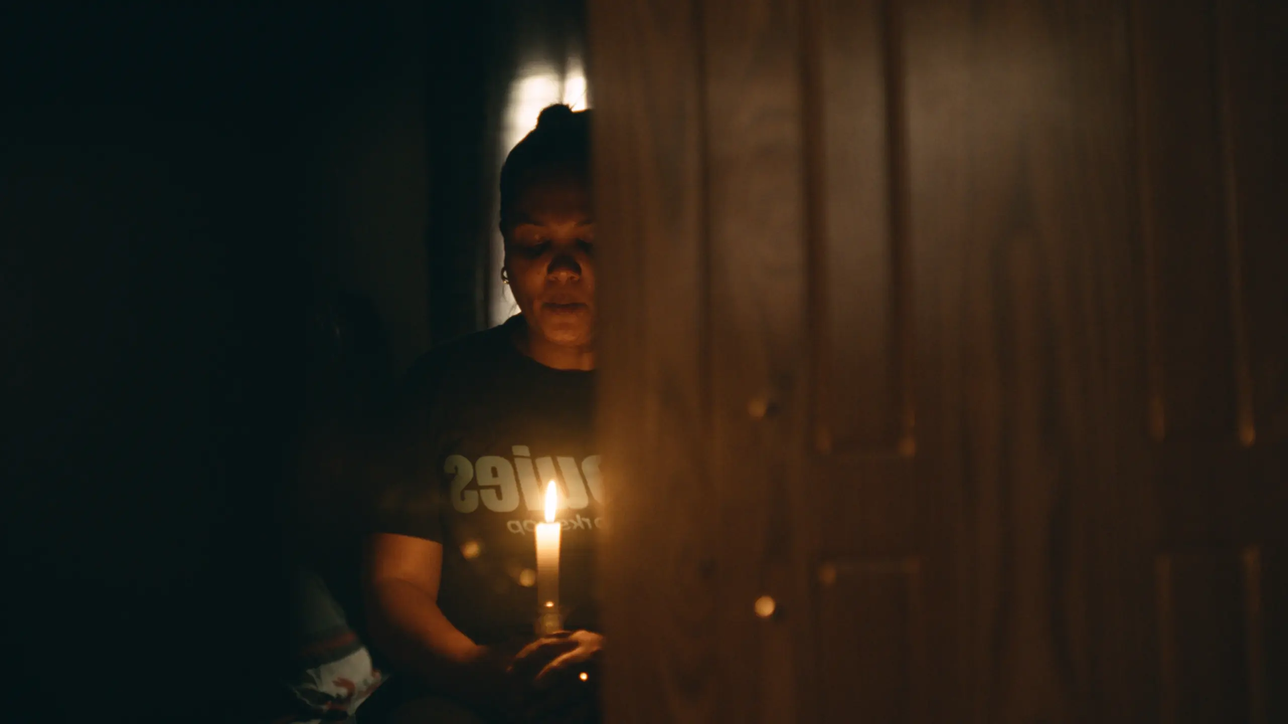 Logan's Mother from the film From Dust We Spin holding a candle.
