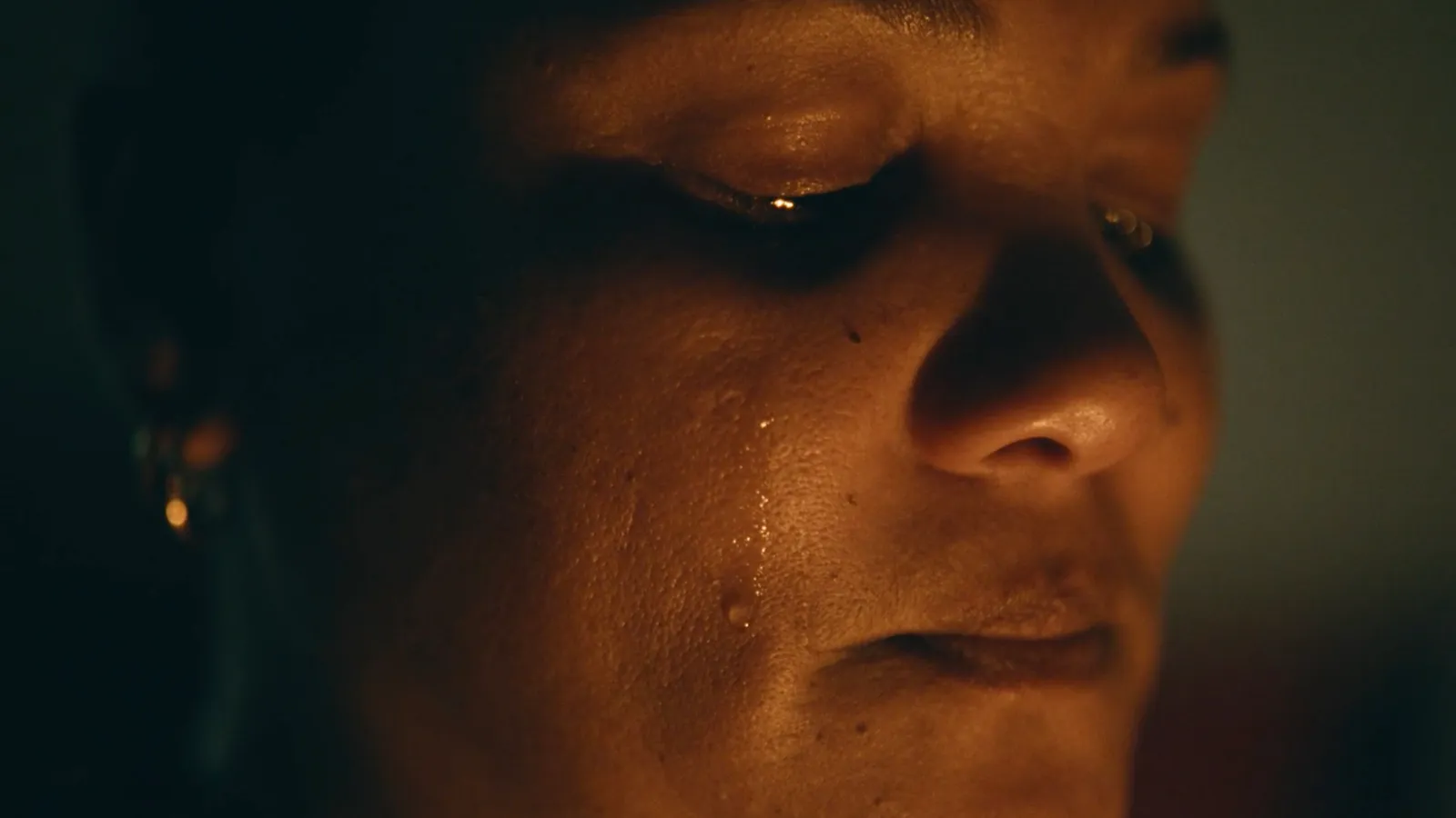 A photograph of Logan's mother shedding a tear from the film From Dust We Spin.